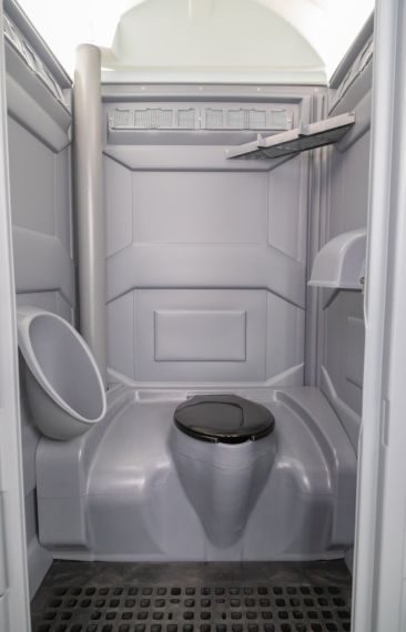 Standard portable toilet interior with seat and urinal