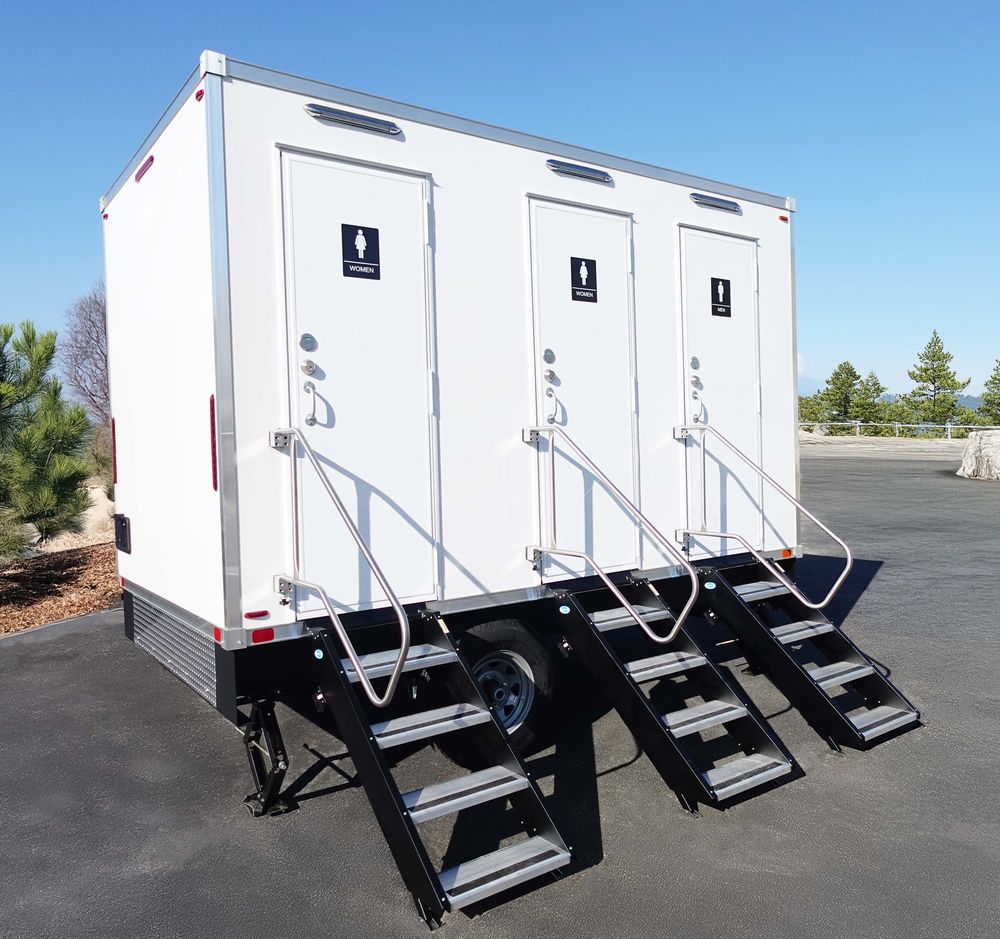Three-station restroom trailer with stairs and handrails